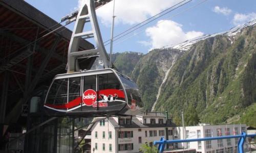 a red and white cable car in front of a mountain at Studio Bel-Hüs / Bel-Häx in Blatten bei Naters