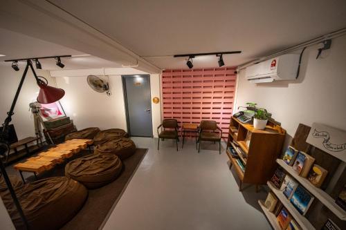 a living room with a couch and a table and chairs at The Brownstone Hostel & Space in Ipoh