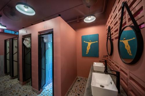 a bathroom with a sink and a mirror at The Brownstone Hostel & Space in Ipoh