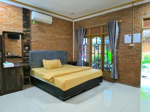 a bedroom with a bed and a brick wall at Wanajaya Homestay 