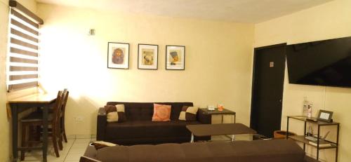 a living room with a couch and a flat screen tv at Departamento Ruze Rosarito Privado-Tranquilo in Plan Libertador