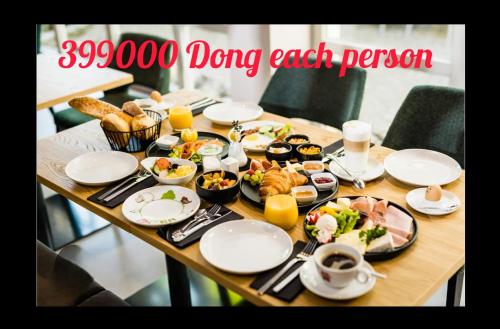 een houten tafel met borden met eten erop bij Beachfront Pool Villa - Lạc Villa in Thăng Bình