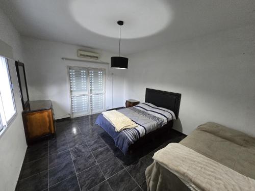 a bedroom with a bed and a dresser and a window at Aguaribay 1 in Chilecito