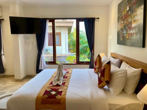 Un dormitorio con una gran cama blanca con ventana. en The L'bok Guesthouse Ubud, en Ubud