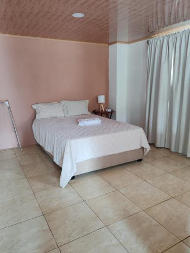 a bedroom with a bed and a tiled floor at Cheni's in Quesada