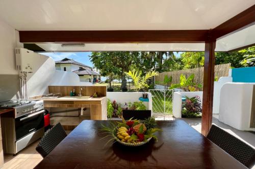 a kitchen with a table with a bowl of fruit on it at Fare Tokatea - Charming Studio w Excl Beach Access in Iumaru