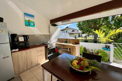 a kitchen with a table with a bowl of fruit on it at Fare Tokatea - Charming Studio w Excl Beach Access in Iumaru