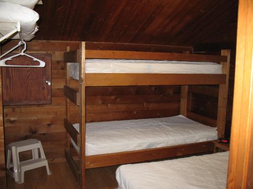 two bunk beds in a room with wooden walls at Forest Lake Camping Resort Lakefront Cabin 2 in Freewood Acres