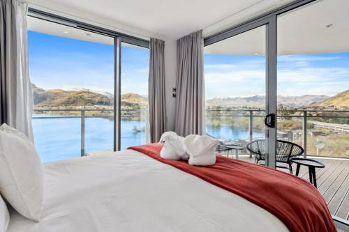 a bedroom with a bed and a large window at Sunlit Serenity Lakefront Apartment in Frankton