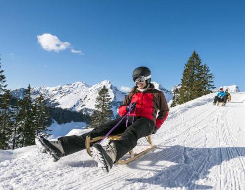 a person sitting on a sled in the snow at Studio Bel-Hüs / Bel-Häx in Blatten bei Naters