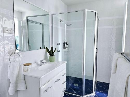 a white bathroom with a sink and a shower at Lake Kami Retreat - Jindabyne in Jindabyne