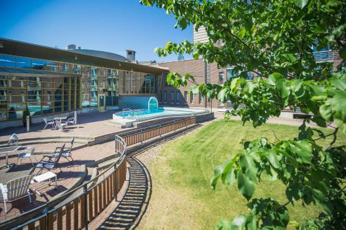 a building with a train track in front of it at Finlandia Hotel Imatran Kylpylä Spa in Imatra