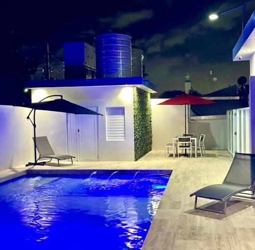 a swimming pool at night with chairs and a table at FYV Beach Villas in San Juan