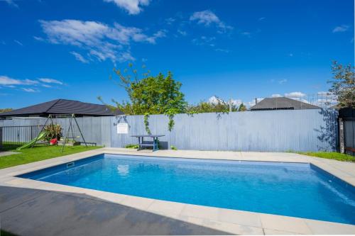 ヘイスティングズにあるFrimley Lodge Motel - with Airport Shuttle service- Best Location in Townの柵の隣の庭のスイミングプール