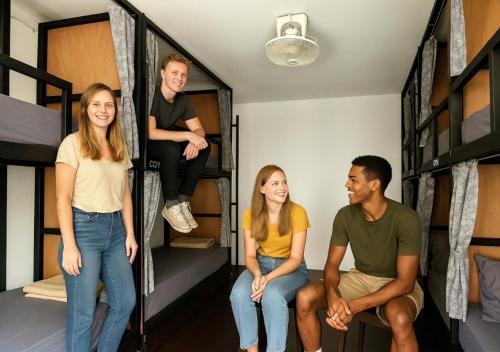 a group of people sitting in their bunk beds at Beanstay hostel in Phuket Town
