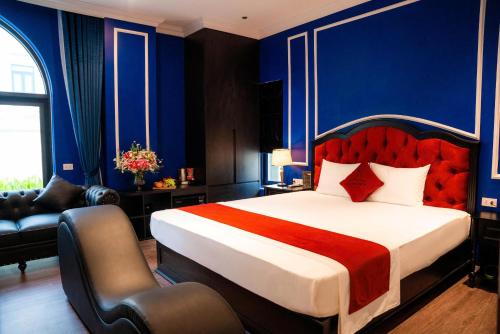 une chambre avec un grand lit et des murs bleus dans l'établissement Lumi Sky Hotel - by BAY LUXURY, à Hà Ðông