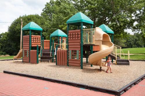a child standing in front of a playground at Circle M Camping Resort Loft Park Model 23 in Wabank