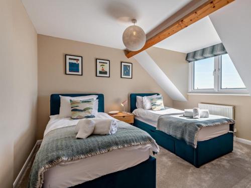 ein Schlafzimmer mit zwei Betten und einem Fenster in der Unterkunft 5 Bed in Worth Matravers DC142 in Worth Matravers