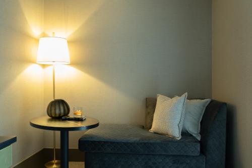 Habitación con sofá azul y mesa con lámpara. en The Lyall, en Melbourne