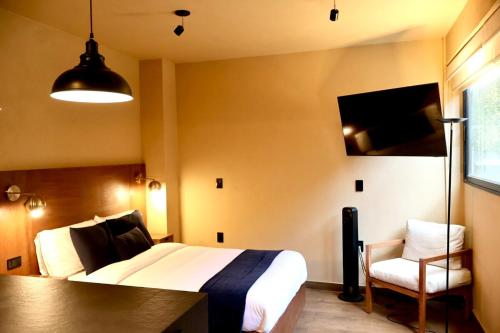 a hotel room with a bed and a chair at A beautiful apartment in the center in Valle de Bravo