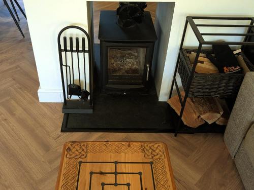a living room with a fireplace and a rug at Newly Refurbished 3 Bed House with 2-Sided Wood Burner and Garden in Edinburgh in Edinburgh