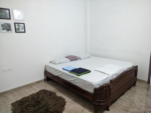 Una cama con sábanas blancas y un libro. en weekend home, for peace & bliss, en Ahmedabad