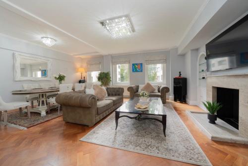 a living room with a couch and a fireplace at The Grande Mayfair Apartment in London