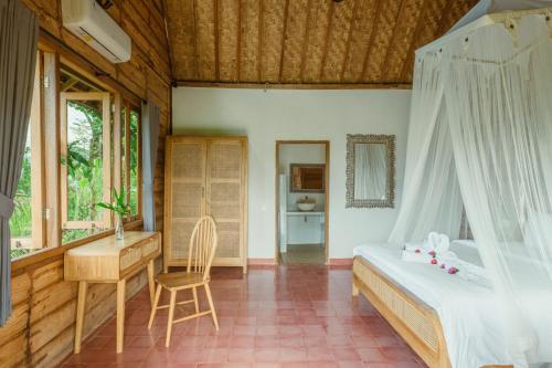 Un dormitorio con una cama, un escritorio y una mesa. en Green vanilla kabin, en Silebeng