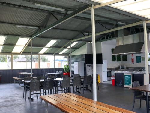 a cafeteria with tables and chairs and a kitchen at BIG4 Breeze Holiday Parks - Busselton in Busselton