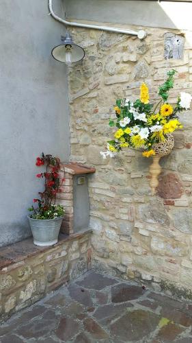 a stone wall with two buckets of flowers on it at Agriturismo Villino del Grillo in San Gimignano