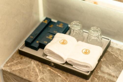 a tray with towels and glasses on a bathroom counter at ShengDa International Hotel in Vientiane
