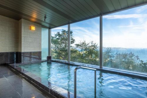 a large swimming pool with a large window at Ijika Daiichi Hotel Kagura in Toba