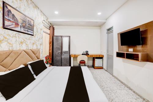 Una habitación de hotel con una cama grande y un escritorio. en Super Hotel O Neopolis Mall Ludhiana Formerly Silver Sky, en Ludhiana