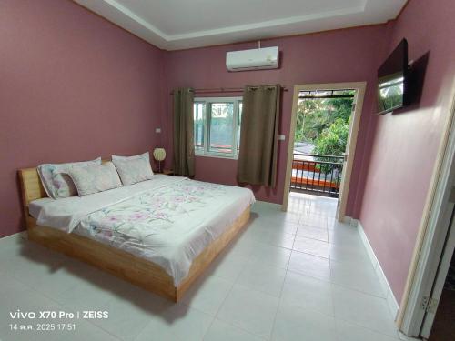 Un dormitorio con una cama grande y un balcón. en Da-Kanda Boutique, en Klong Muang Beach