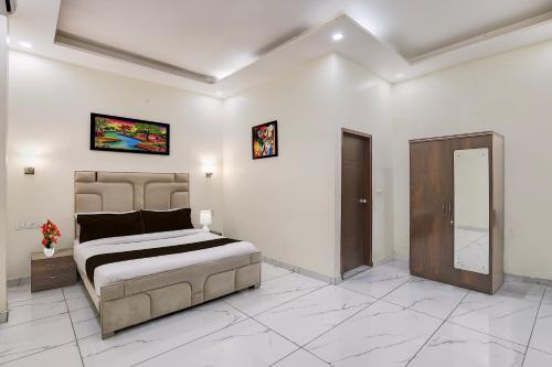 a bedroom with a king sized bed in a room at Super Hotel O Clock Tower Dehradun Formerly Dooncity Suites in Dehradun