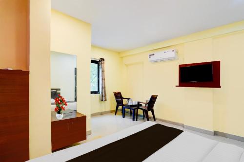 SurūrnagarにあるSuper Hotel O LB Nagar Metro Station Formerly Virat residencyのベッド、テーブル、椅子が備わる客室です。