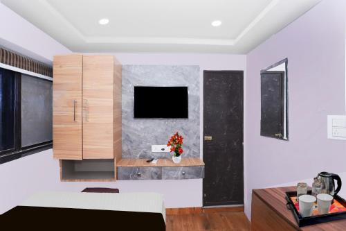 ラーンチーにあるSuper Townhouse Rauniyar City Centre Ratu Roadの壁にテレビが取り付けられたリビングルーム