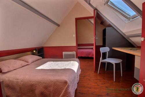 a bedroom with a bed and a table and a mirror at Ker desiree in Plélo