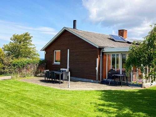 a house with a table and chairs in a yard at 6 person holiday home in Augustenborg in Augustenborg