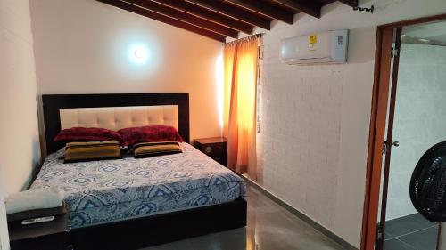 une chambre avec un lit avec des oreillers rouges dessus dans l'établissement Hermosa casa en Cartago V, à Cartago