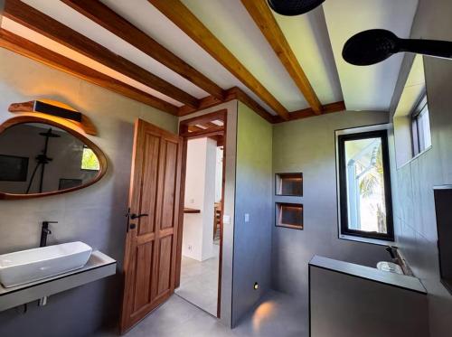a bathroom with a sink and a mirror at Kupu Kupu Villas Mentawai in Katiet