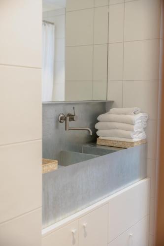 a bathroom with a sink with towels on a counter at The Heads Bath House in Barwon Heads