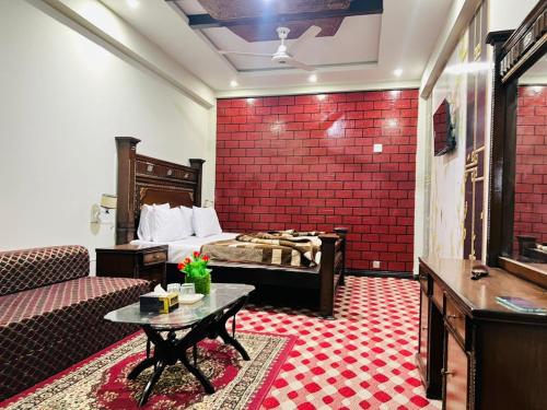 een hotelkamer met een bed en een rode muur bij UK Hotel in Abbottābād