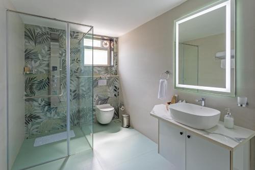 a bathroom with a glass shower and a sink at Lamrin Morjim Goa in Morjim