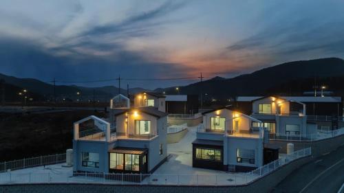 a large house with lights on top of it at night at The Blue 101 Pool Villa in Hajŏng-ni