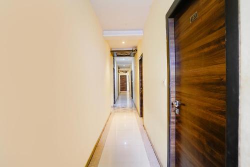 an empty corridor with a wooden door in a building at Via New Silver Elite in Mumbai