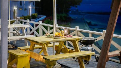 a picnic table on a deck with a grill at Namhae Melody Kids Private Pension in Sukho
