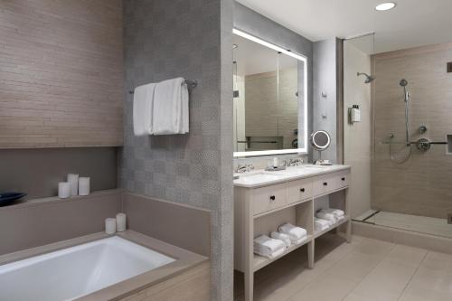a bathroom with a tub and a sink and a mirror at Grand Hyatt Tampa Bay in Tampa
