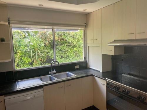 una cocina vacía con fregadero y ventana en 55 See Street Bargara, en Bargara