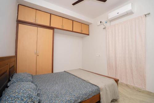 a bedroom with a bed and a cabinet and a window at Cozy 2BR in Chennai